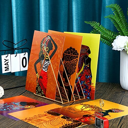Colorful African art prints displayed on a table.