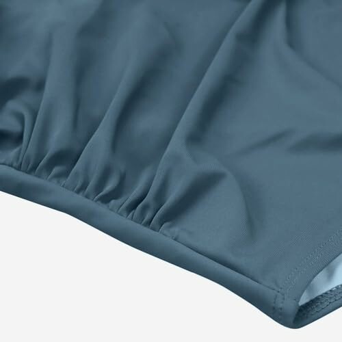 Close-up of blue athletic wear fabric with gathered seam.