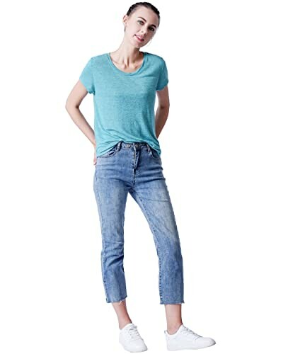 Woman in blue t-shirt and jeans standing casually.