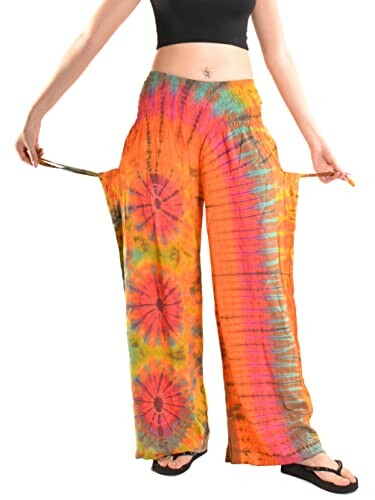 Person wearing colorful tie-dye pants with floral patterns and adjustable sides.