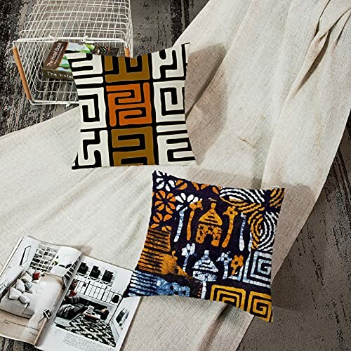 Two decorative cushions with modern patterns on a draped fabric.