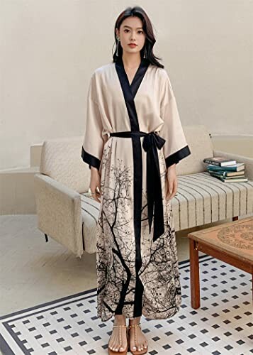 Woman wearing an elegant robe with black trim and branch pattern.