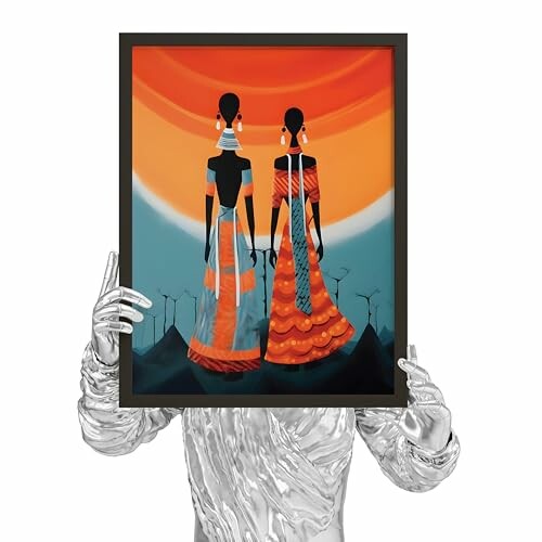 Person holding framed art of two silhouetted figures in vibrant colors.