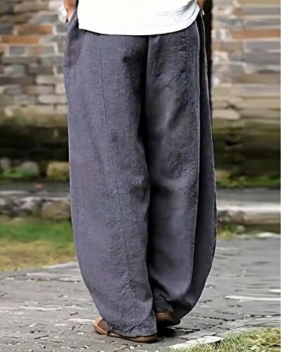 Person wearing gray loose-fit linen pants standing outdoors.