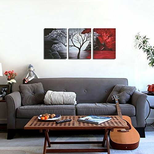 Living room with a grey couch, wall art, and a guitar on a coffee table.