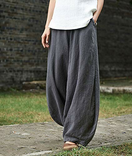 Person wearing loose gray harem pants and white top.