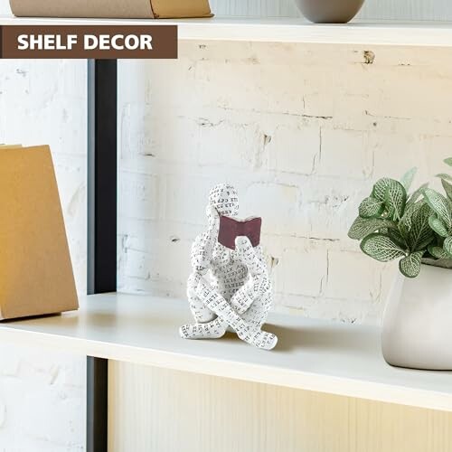 Decorative statue of a person reading on a shelf