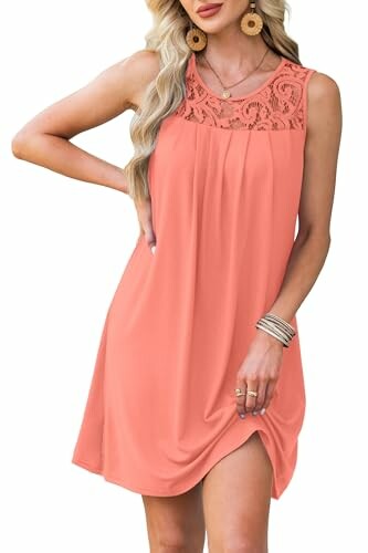Woman wearing a sleeveless coral dress with lace neckline.