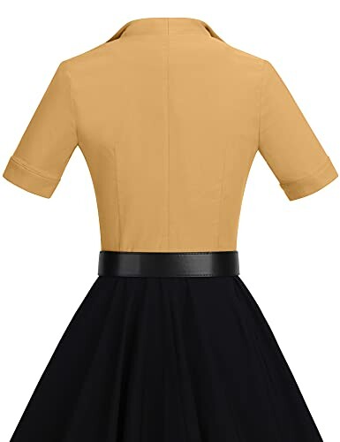 Back view of a vintage yellow top and black skirt dress with belt.