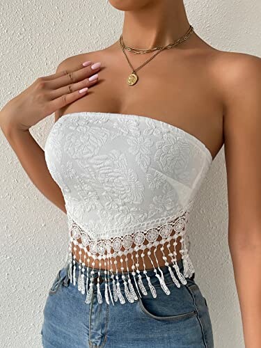 Woman wearing a white lace tube top with denim jeans.