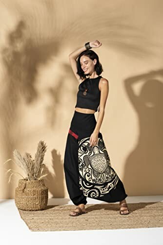 Woman in bohemian style outfit posing with decorative bag.