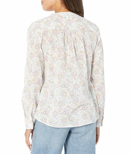 Woman in floral blouse and jeans, back view