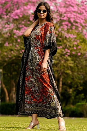 Woman in red and black patterned kaftan with sunglasses, standing outdoors