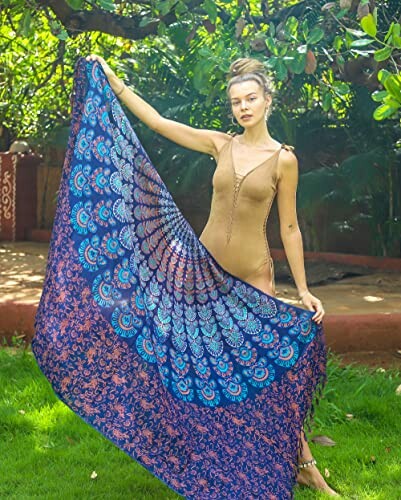Woman holding a blue and orange peacock mandala tapestry outdoors.