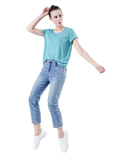 Woman in blue t-shirt and jeans, white background.