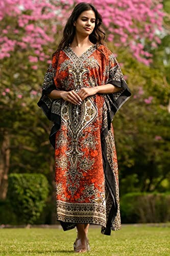 Woman in colorful kaftan standing outdoors with pink flowers in background.