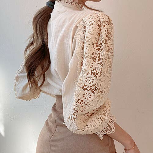 Woman in a lace sleeve blouse and beige skirt.