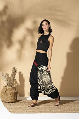 Woman posing in bohemian style pants with a decorative pattern.