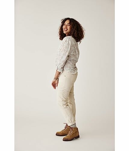 Woman standing and smiling in beige outfit
