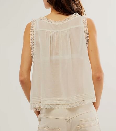 Woman in sleeveless lace-trimmed top, back view.