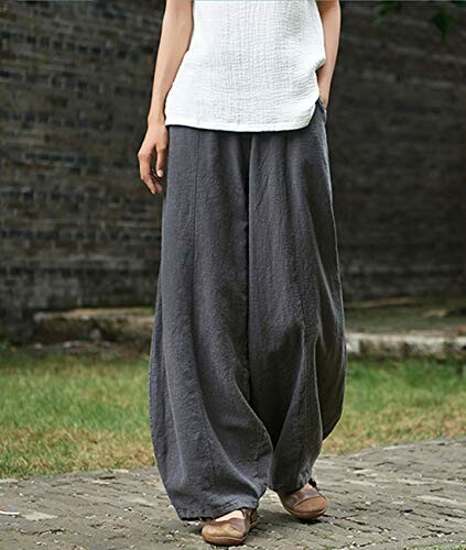 Woman in wide-leg gray pants and white top outdoors.