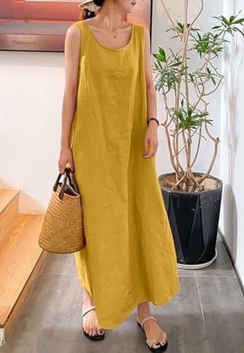 Woman in yellow summer dress holding a woven bag, standing near a potted plant.