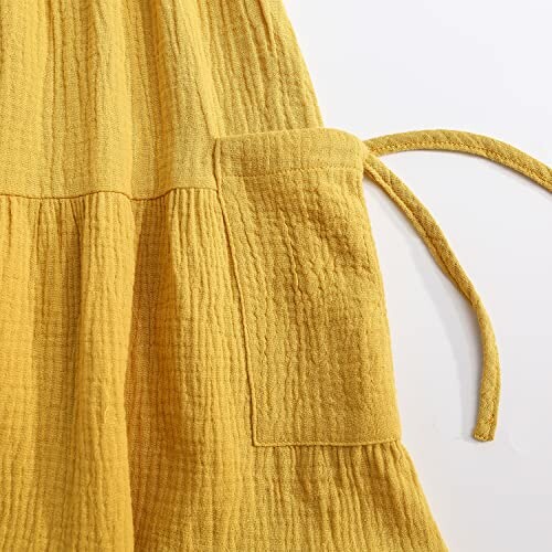 Yellow textured fabric with a pocket and tie.