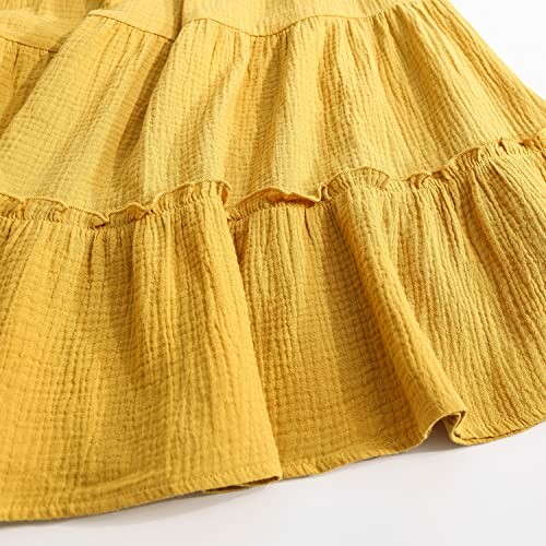 Close-up of yellow tiered fabric with textured pattern.