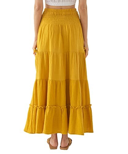 Back view of a yellow tiered maxi skirt worn by a person.